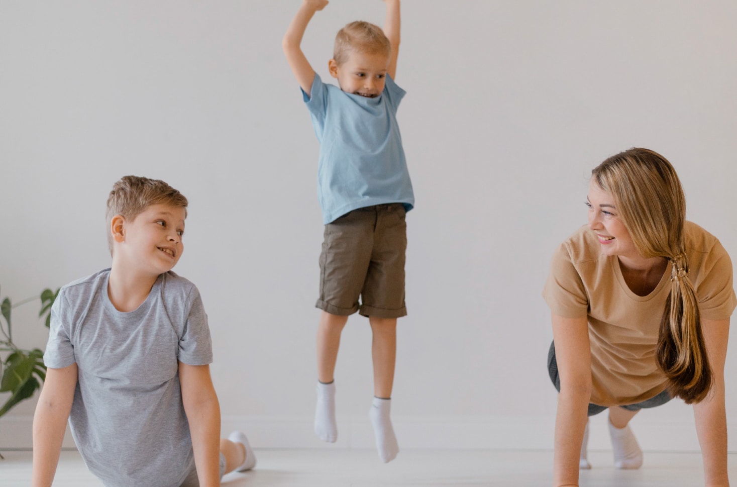 Two male children doing exercises together with an adult woman